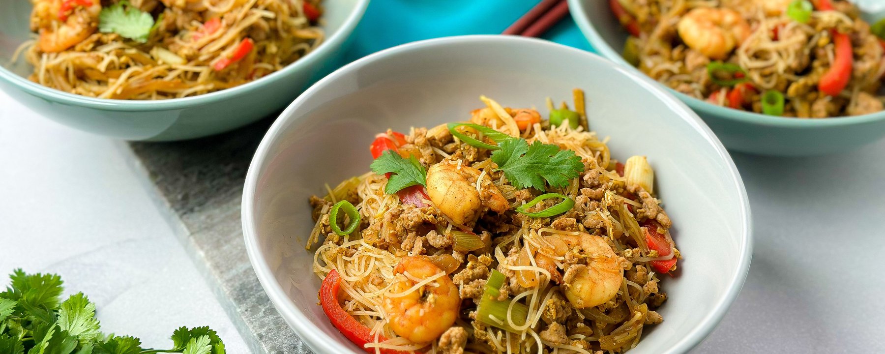 Three bowls of stir-fried noodles with prawns, vegetables and minced meat