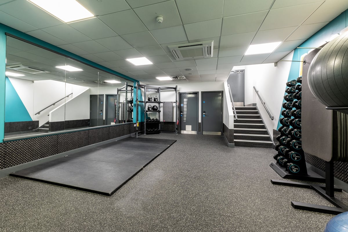 PureGym Cambridge Leisure Park: Gym studio with turf area, free weights, resistance machines, and rubberised flooring.