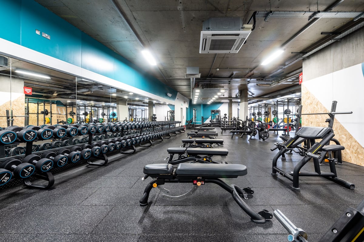 PureGym London Limehouse: Rows of dumbbell racks, benches, weight plates, and exercise machines.