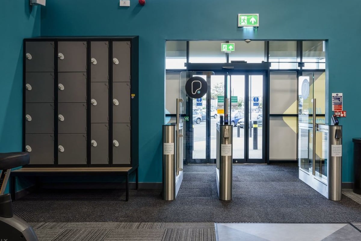 PureGym Falkirk: Lockers, entrance doors, directional signage - appears to be a gym reception area.