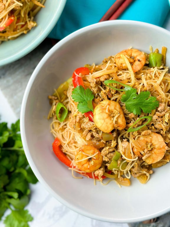 Rice noodles with prawns, minced meat, red peppers, spring onions, and coriander leaves in