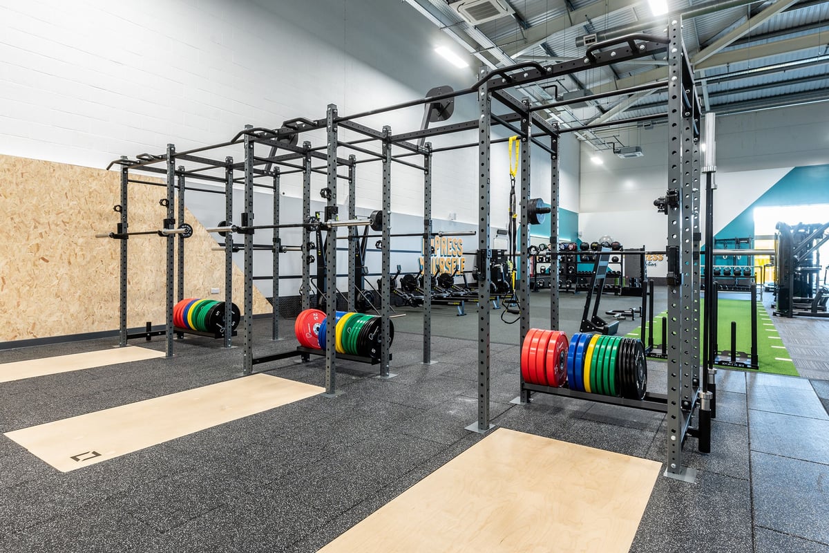 PureGym Portishead: Rig frames, coloured weight plates, rubberized floor platforms.