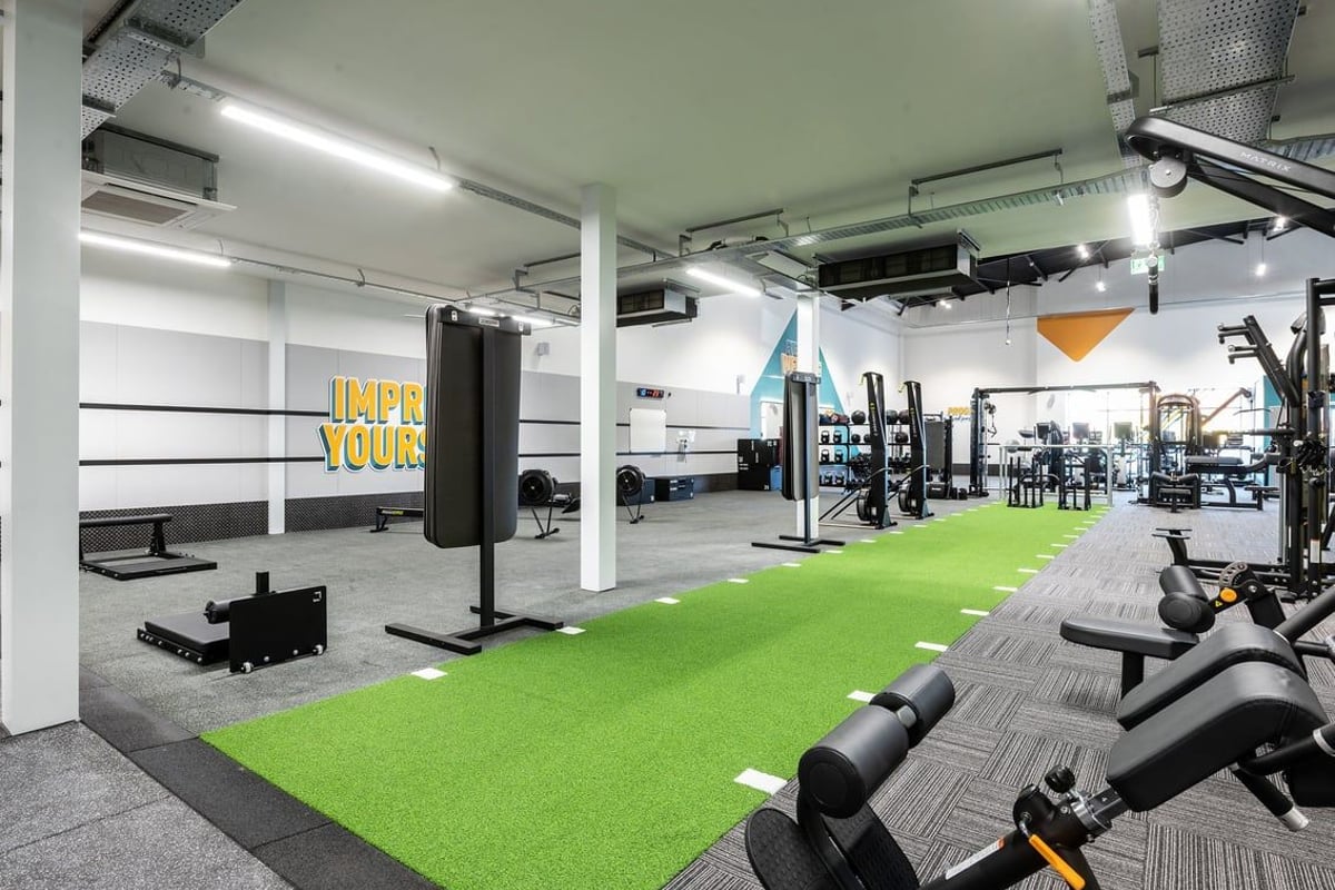 PureGym Durham Arnison: Gym interior with green turf area, boxing bags, weight racks, benches, and resistance machines.