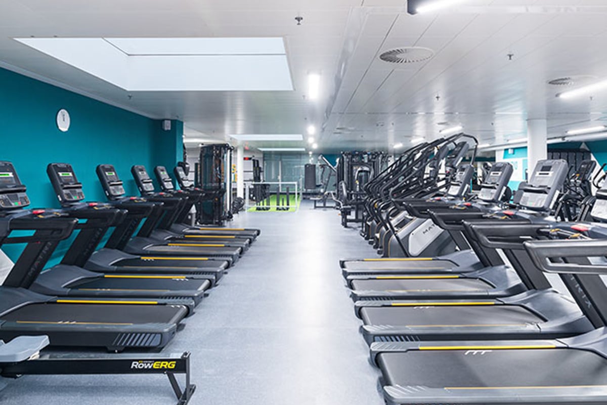 PureGym Fribourg: Des rangées de tapis roulants et de vélos stationnaires.