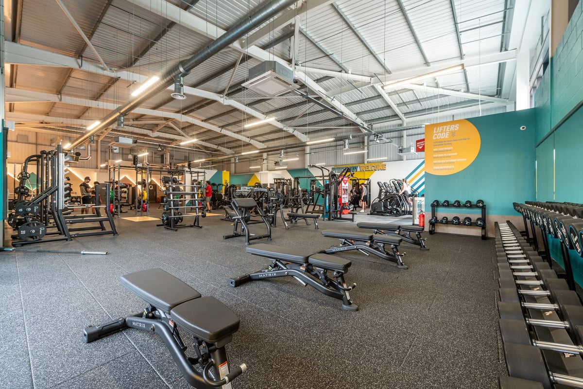 PureGym Spalding: Racks of weights, benches, rubberized floor in a well-equipped gym facility.