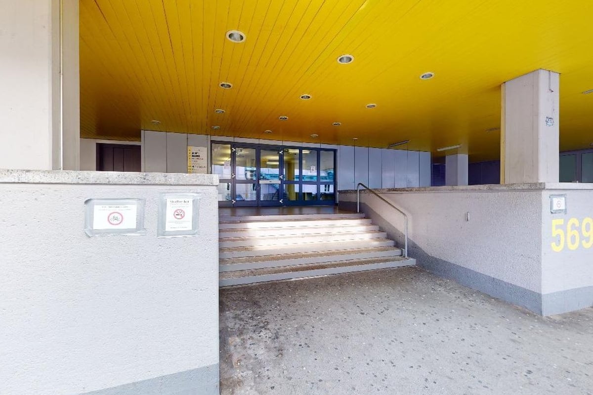 PureGym Altstetten: Schwach beleuchteter Eingangsbereich mit Zugangstoren und Empfangstheke.