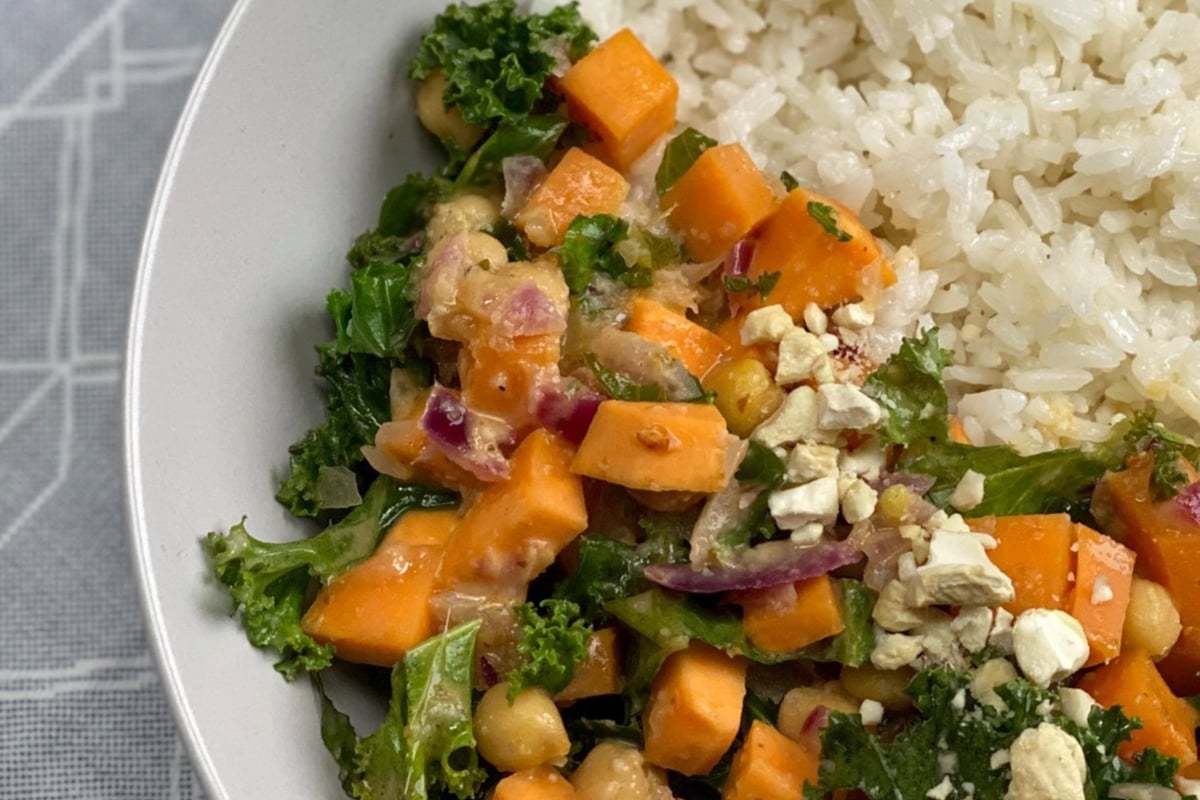White rice served with a vegetable and chickpea salad topped with chopped nuts