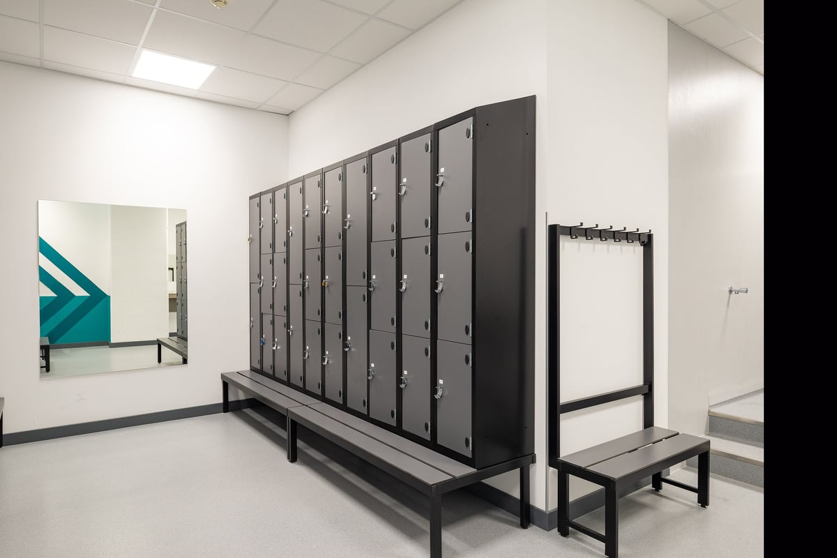 PureGym La Chaux-de-fonds: Grey lockers and benches in the gym's changing room area.