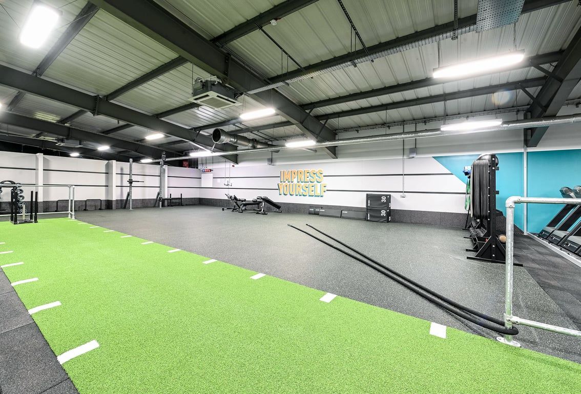 PureGym Canterbury Sturry Road: Indoor gym space with turf area, weight racks, and functional training equipment.