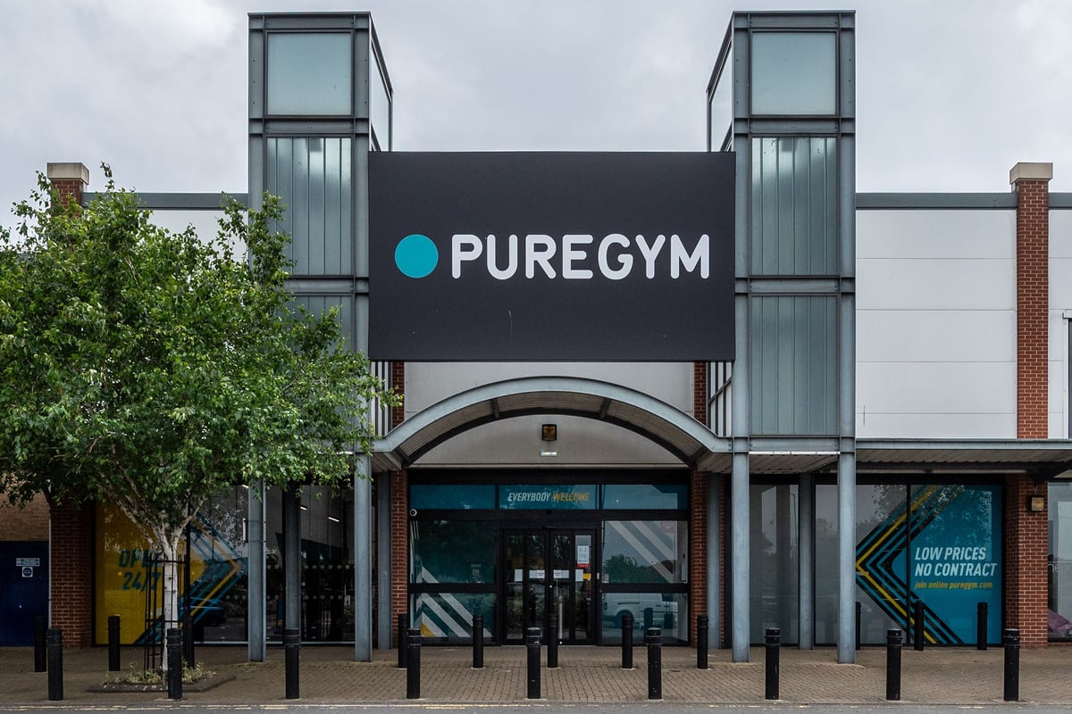 PureGym Thamesmead: Exterior of a gym facility with signage "PUREGYM", glass entrance, and surrounding landscaping.
