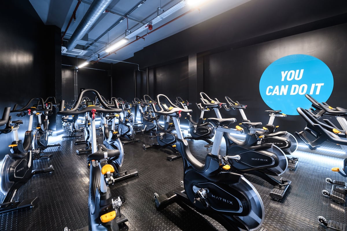 PureGym Basildon: Rows of stationary bikes inside a dimly lit studio with motivational signage.