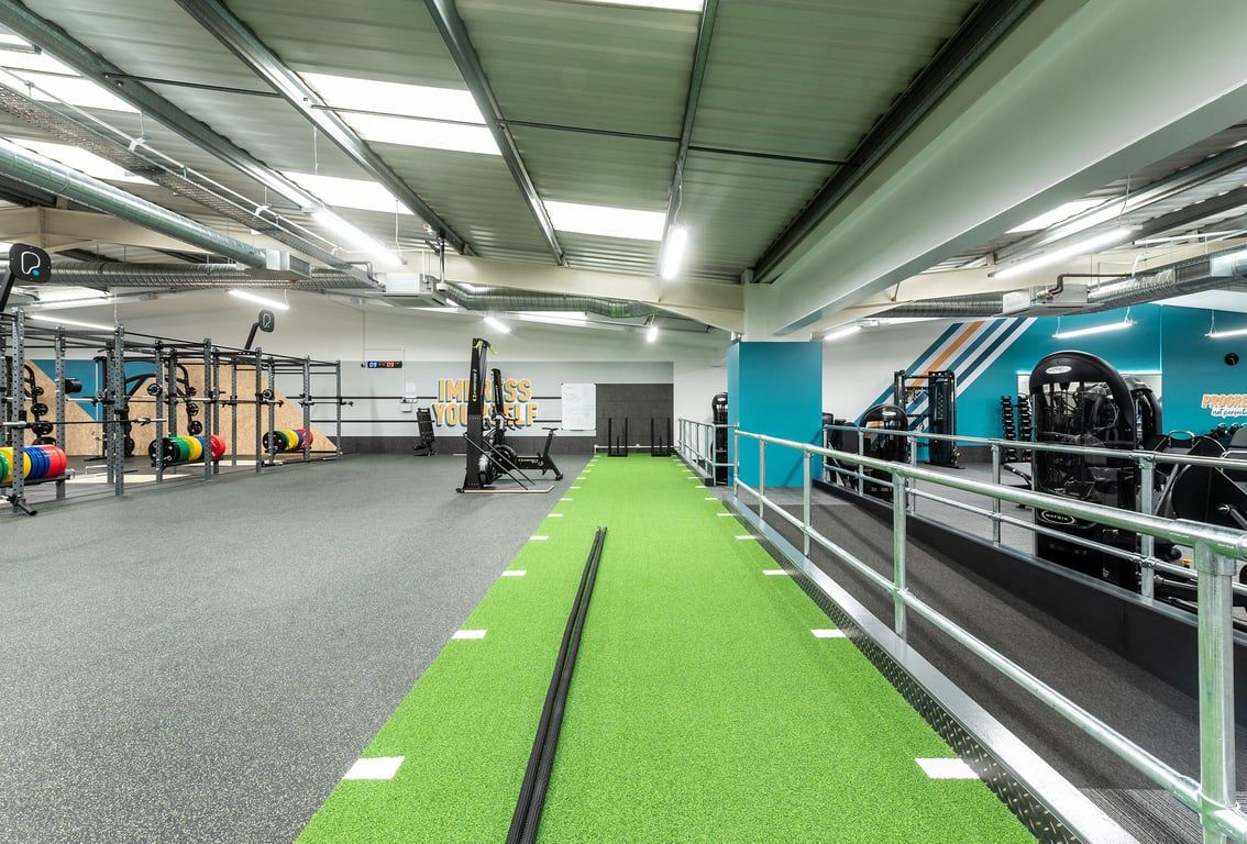PureGym Cardiff Western Avenue: Functional training area, rig frames, resistance machines, turf track, weight racks.