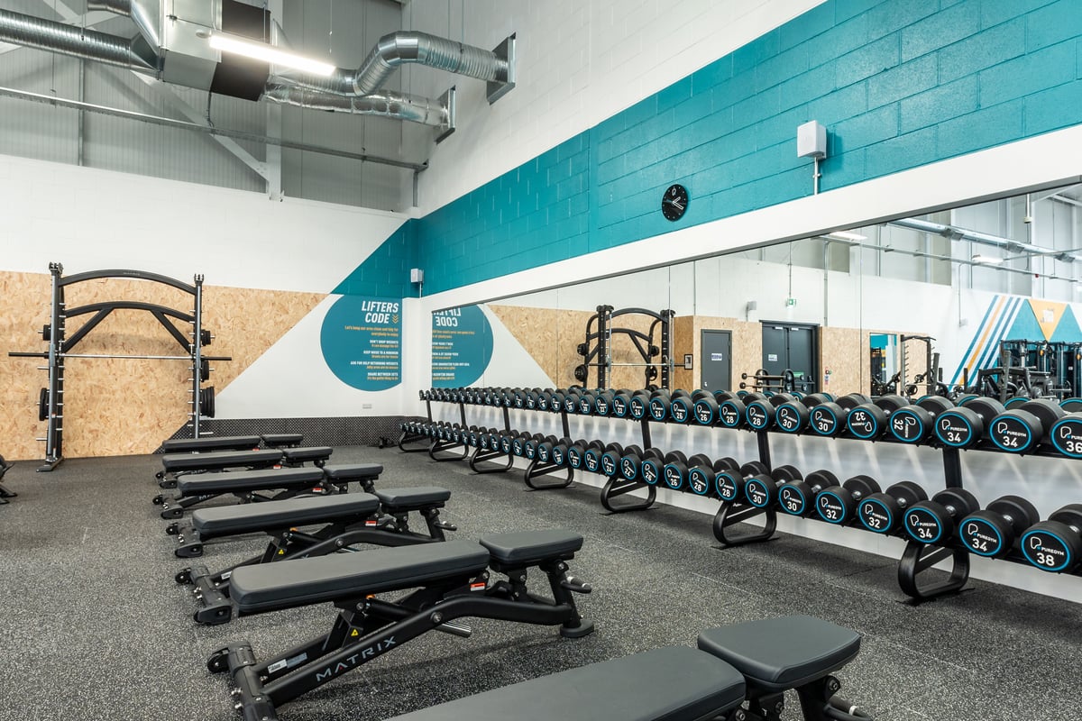 PureGym Port Talbot: Rows of resistance machines, benches, free weights, and rubberized flooring in a gym space.