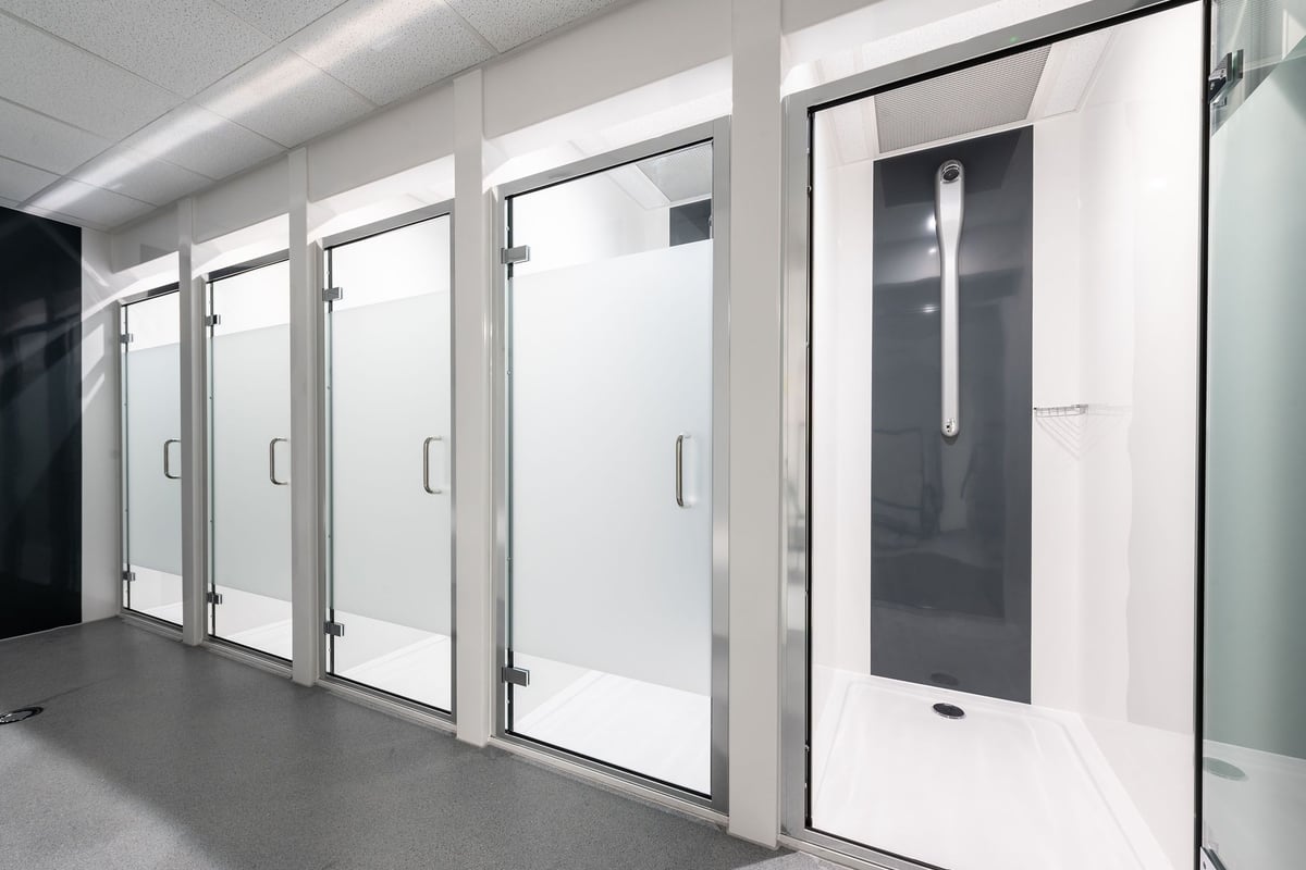 PureGym Bournemouth Mallard Road Retail Park: Rows of glass-paneled entry gates with aluminum frames and door handles.