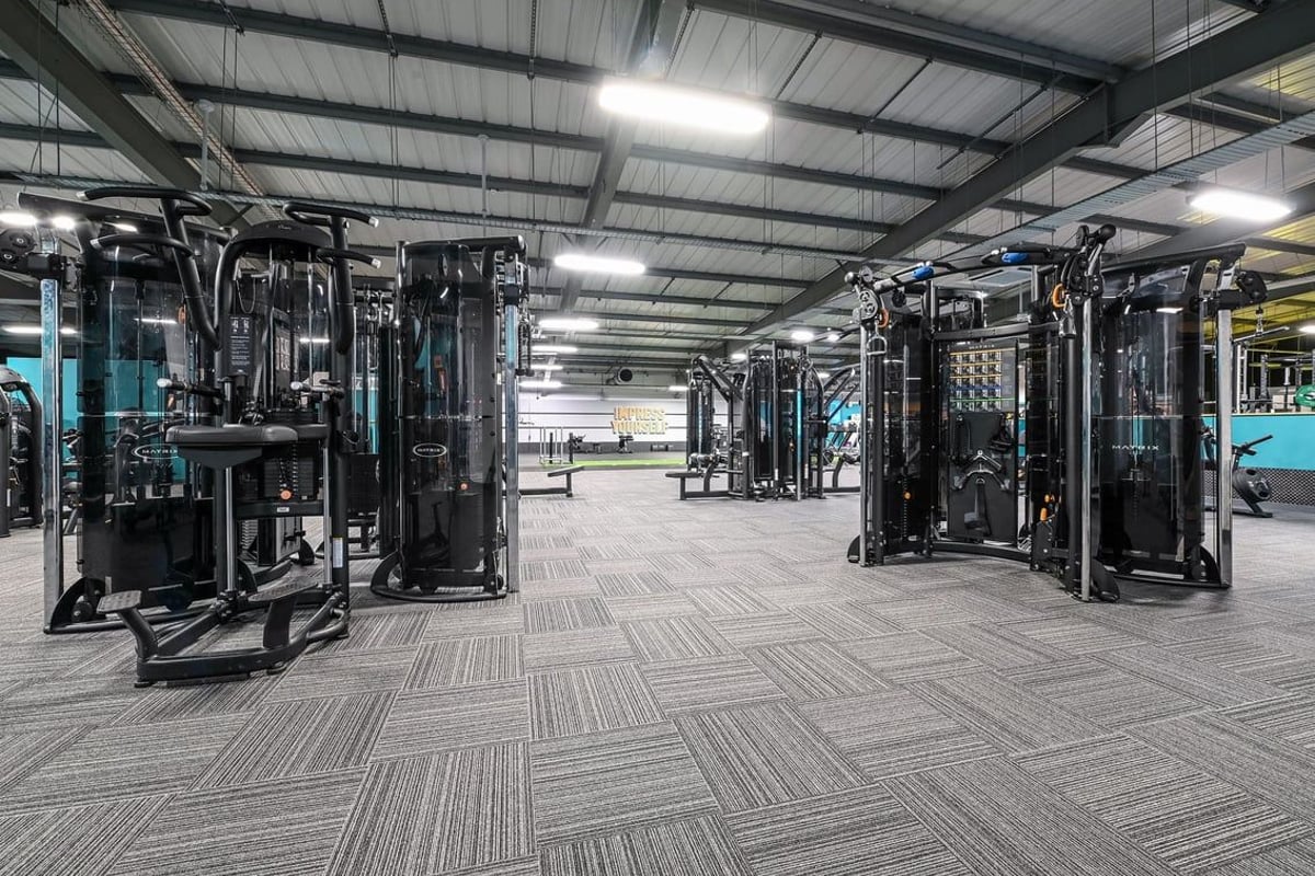 PureGym Canterbury Sturry Road: Rows of resistance machines, cable crossovers, and rubberized flooring in a gym setting.