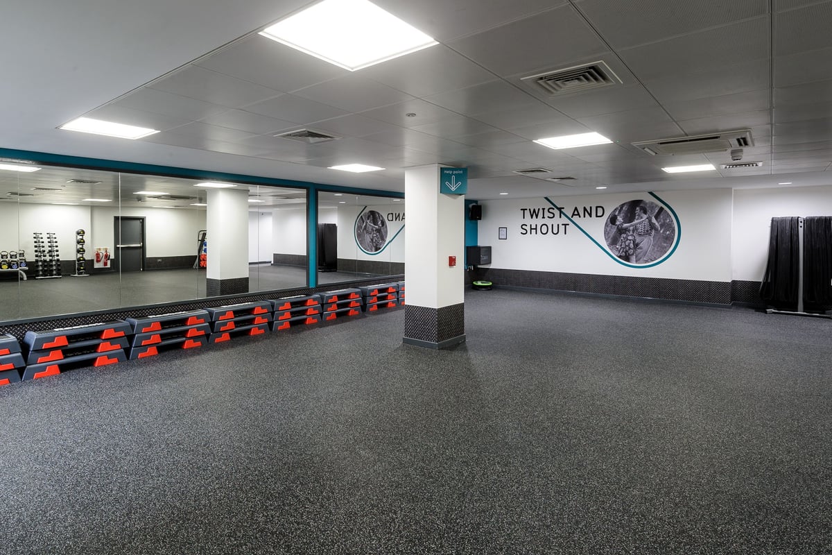 PureGym Glasgow Hope Street: Spin studio with stationary bikes, mirrors on walls, and stadium-style seating.