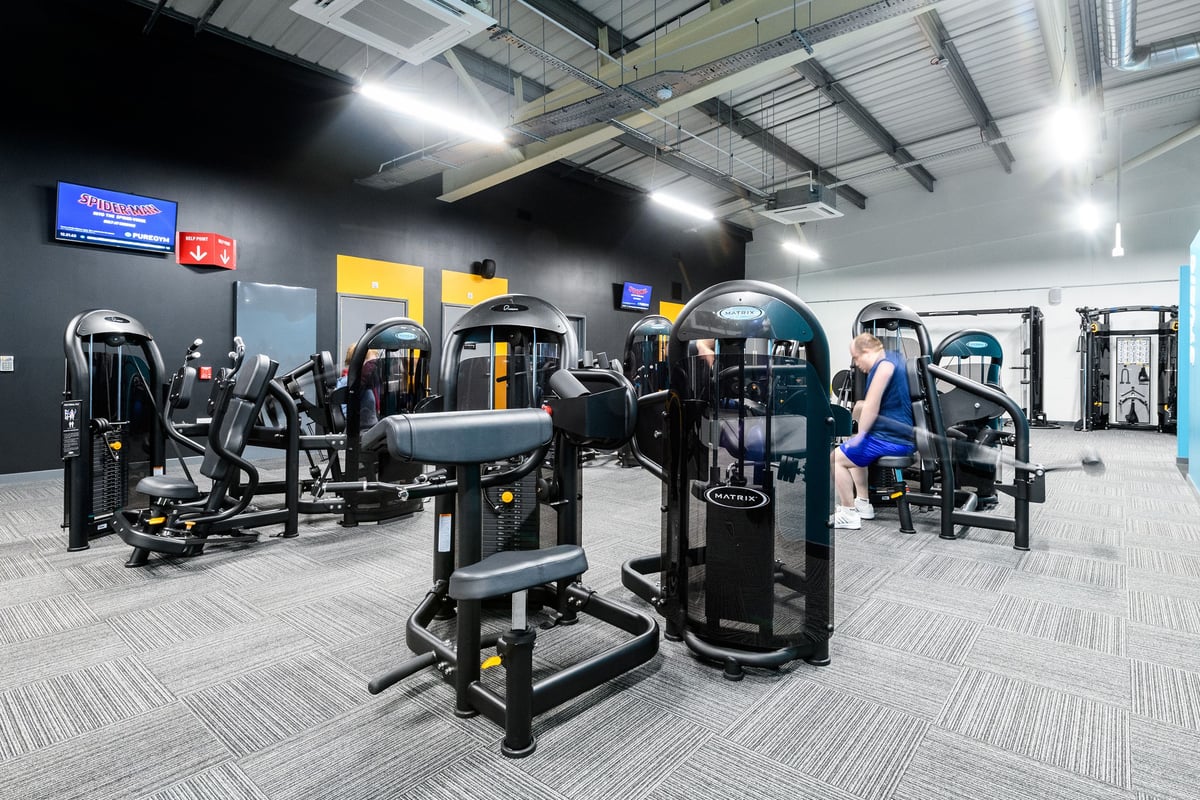 PureGym Cardiff Bay: Rows of cable machines, leg presses, weight stacks, and resistance equipment inside a gym.