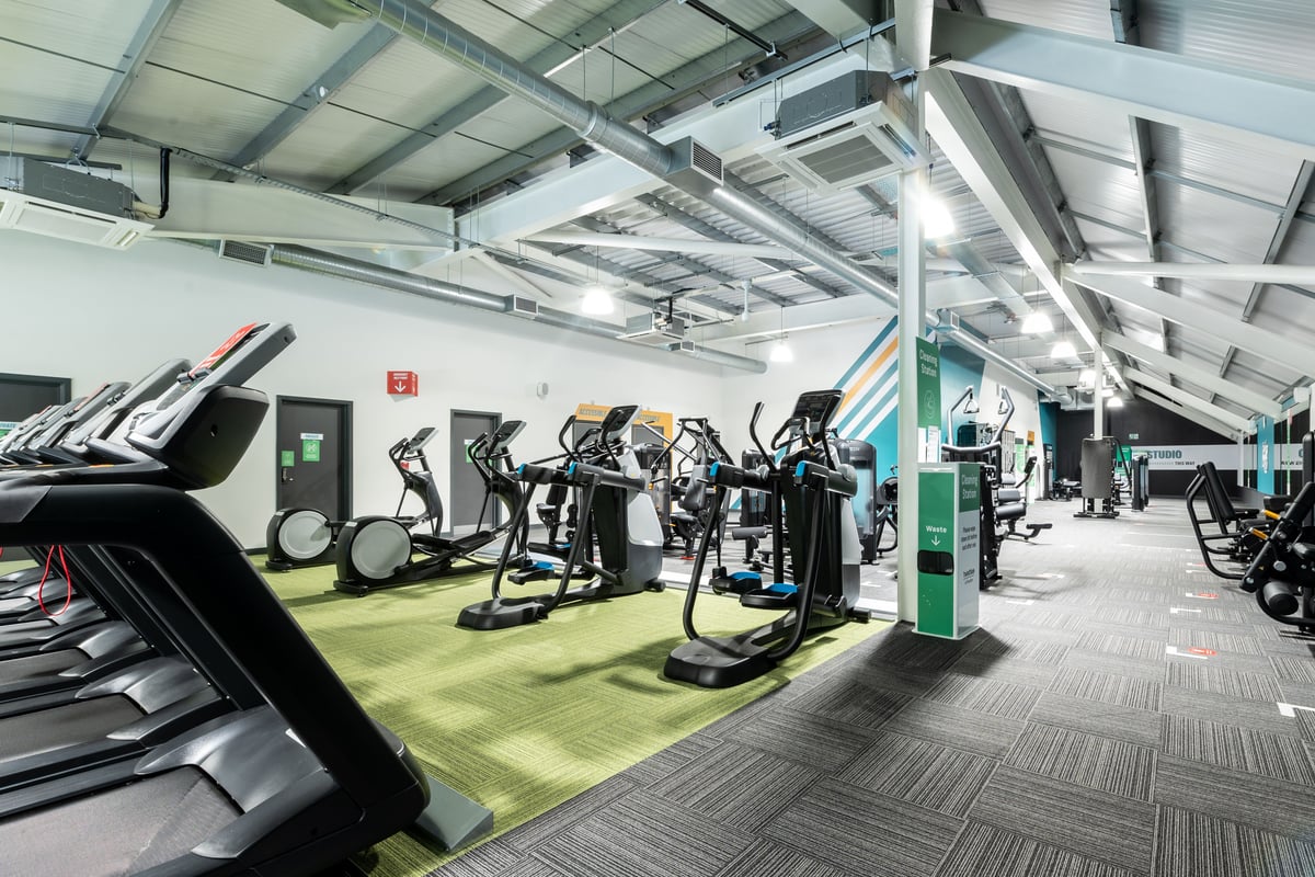 PureGym Plymouth Marsh Mills: Rows of treadmills, ellipticals, stationary bikes in a gym with high ceilings.