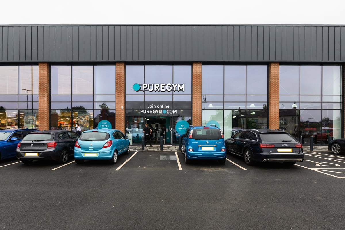 PureGym Bromsgrove Retail Park: Pure Gym exterior with parked cars and entrance displaying its branding.