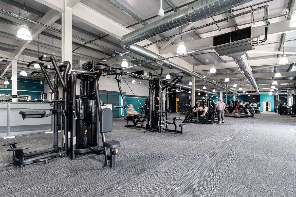 PureGym Portsmouth North Harbour: Functional training area with weight machines, cable pulleys, and rubberized flooring.