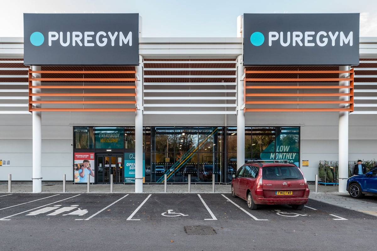 PureGym Alton: The image shows the exterior of two PureGym fitness centers with visible storefronts and a parking area.