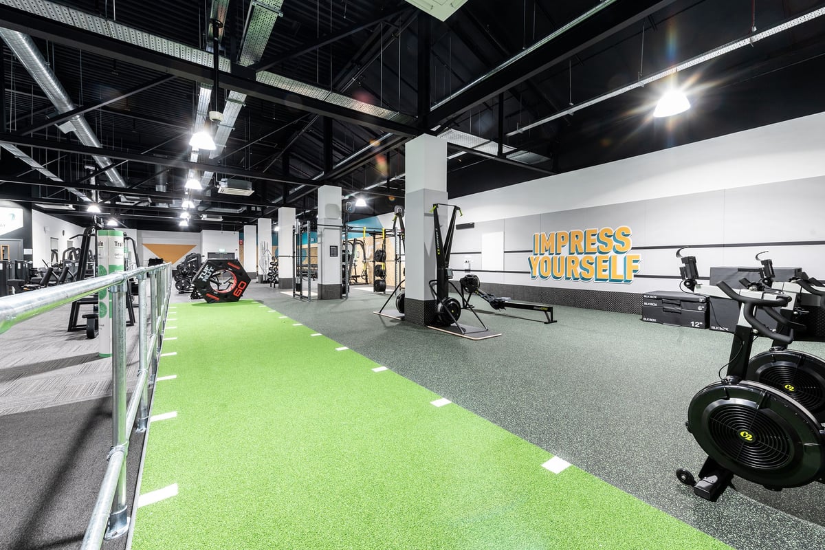 PureGym Bracknell: Weights, bikes, turf area, resistance machines in industrial-style gym space with motivational wall text.