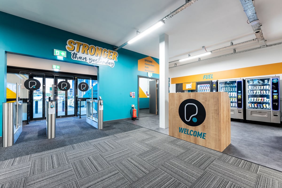 PureGym Boston: Entry area with speed gates, welcome podium, and food and beverage vending machines.