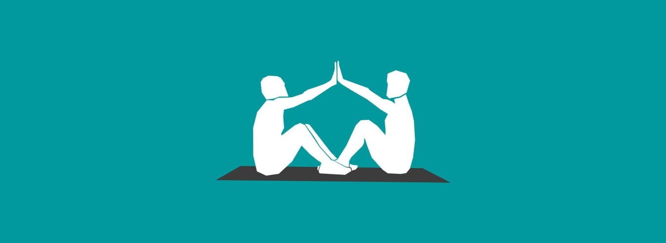Two people sitting on a mat facing each other with hands touching in a high-five pose