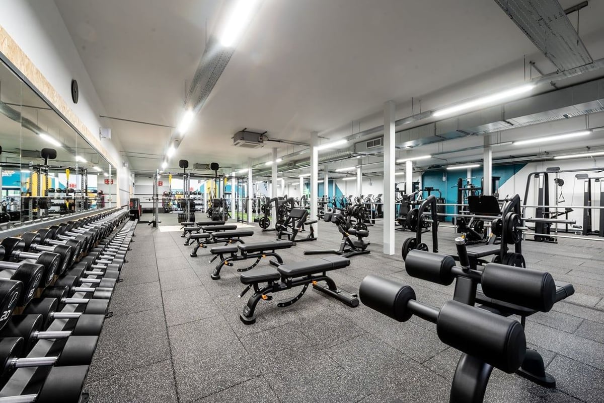 PureGym Inverness Inshes Retail Park: Gym with rows of weight machines, benches, free weights, and rubberized flooring.