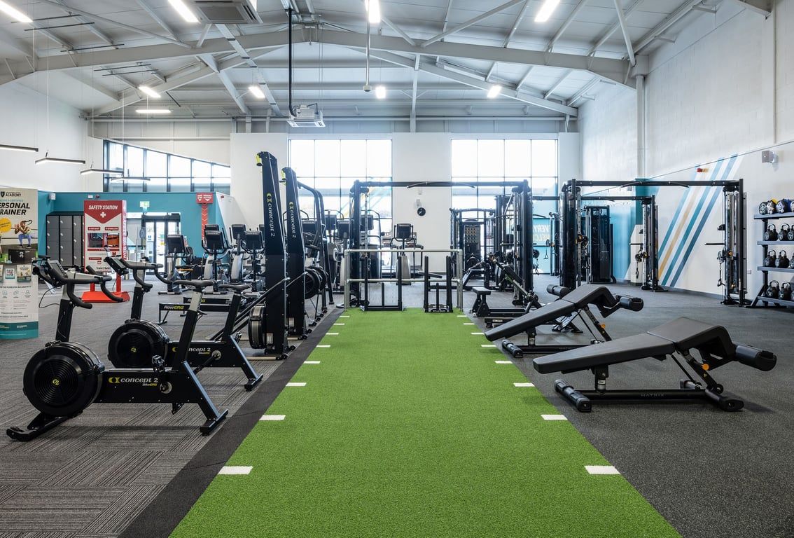 PureGym Falkirk: Weight machines, resistance equipment, free weights, turf area within a spacious gym studio.