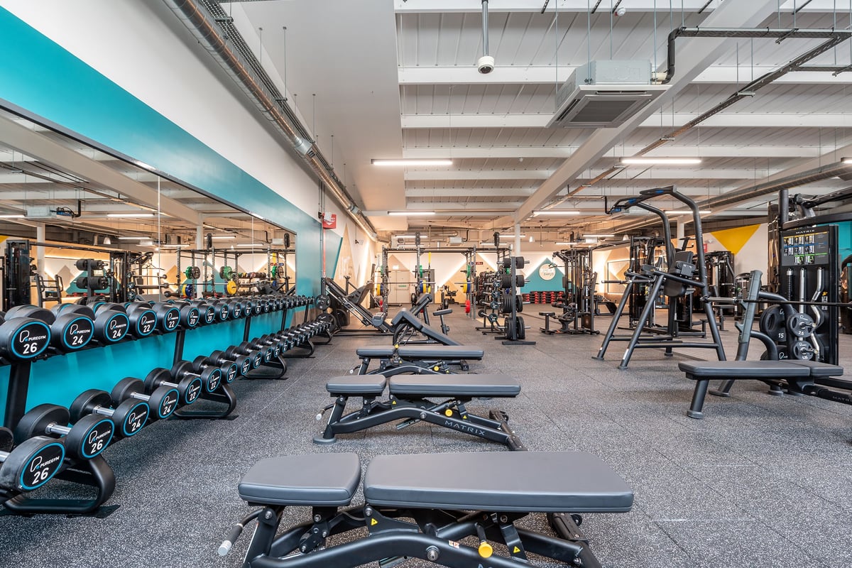 PureGym Bideford: Weight benches, dumbbell racks, resistance machines, and rubberized flooring in a commercial gym setup.