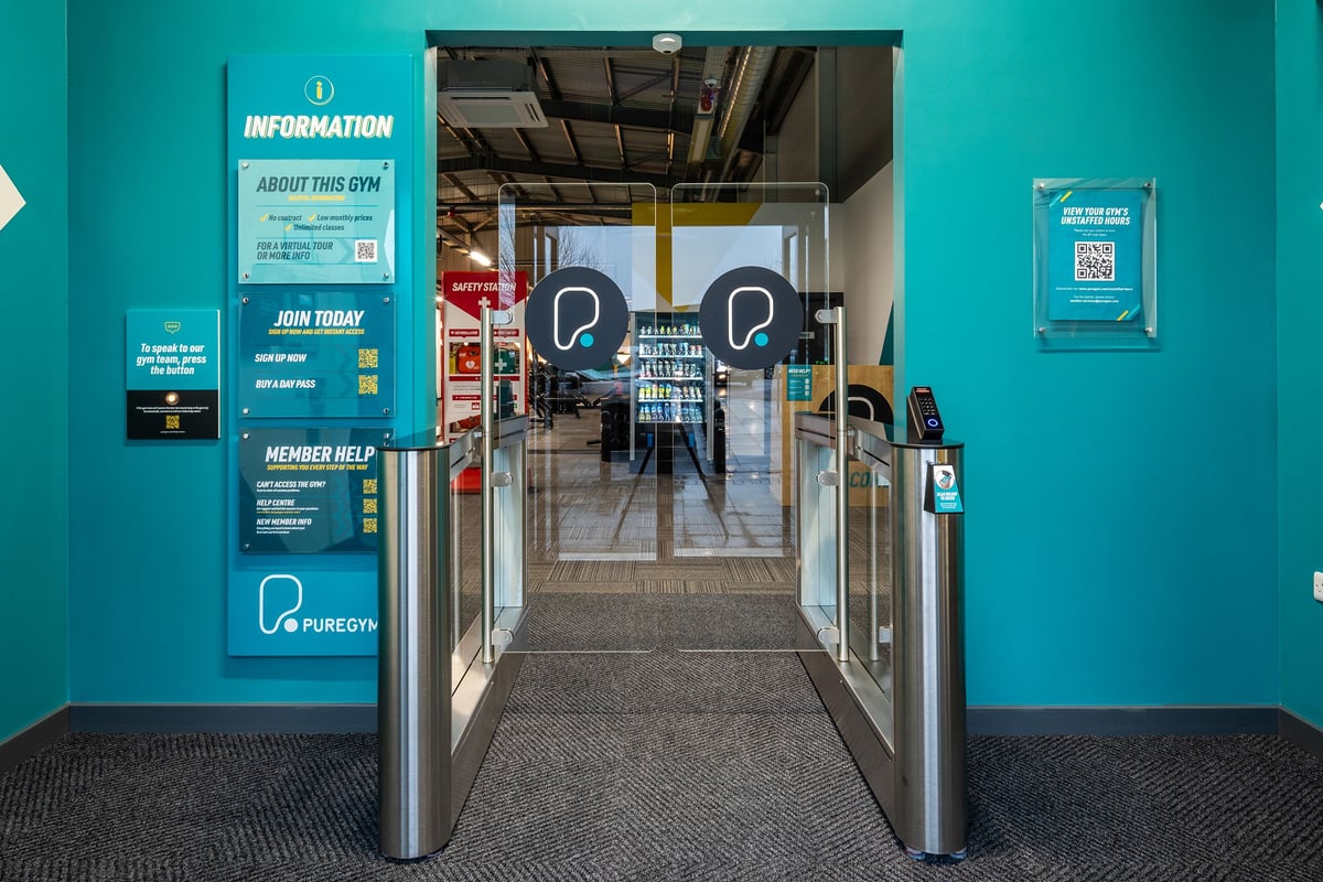 PureGym Wantage: Front entrance area with turnstiles, informational signage, and gym branding.