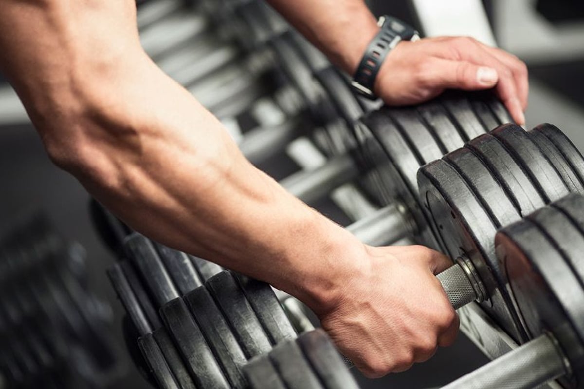 Arm picking up dumbbell