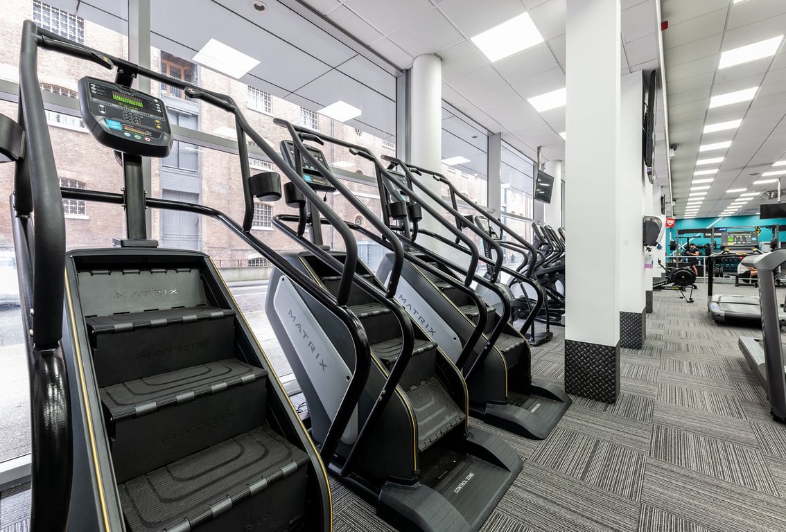 PureGym London Canary Wharf: Rows of treadmills and elliptical cross-trainers in a bright gym space.