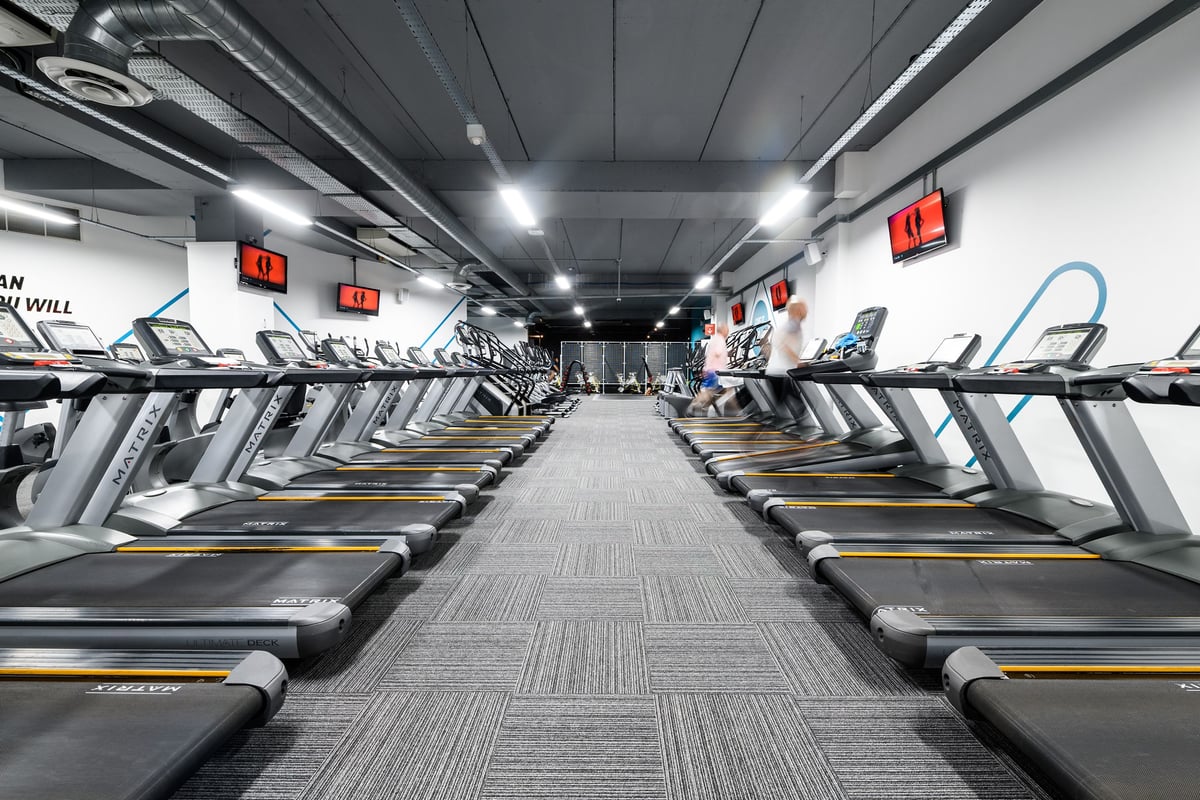 PureGym Bournemouth The Triangle: Rows of treadmills with digital displays in a gymnasium-style setting.
