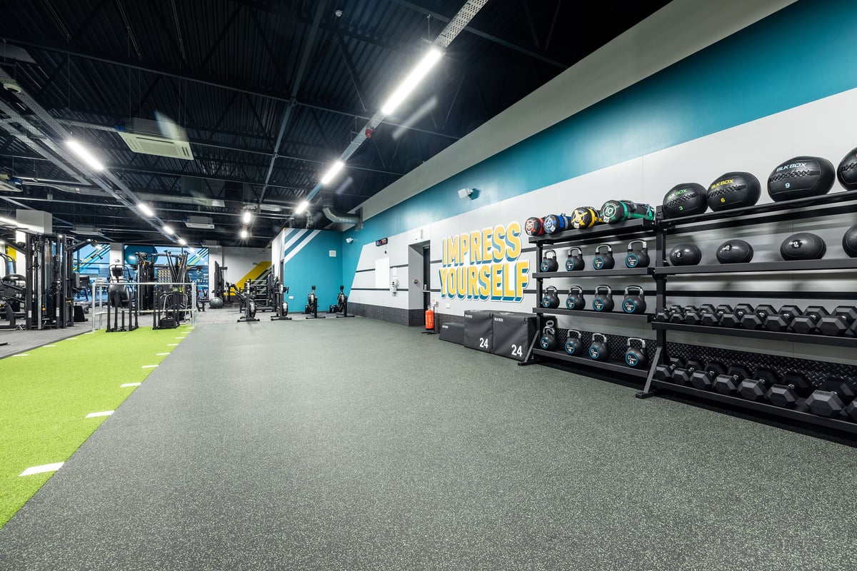 PureGym Washington: Weight racks, medicine balls, rubberized floor, and wall branding for 'Fitness Yourself'.