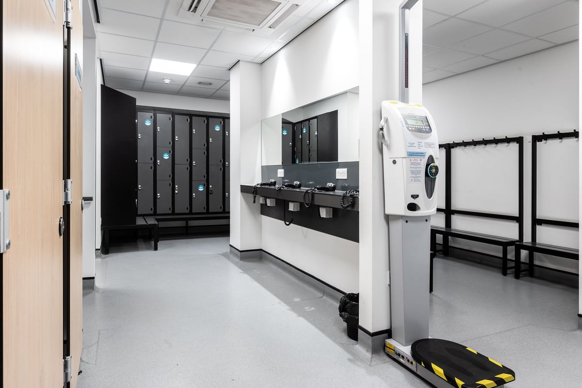 PureGym Stevenage: Rows of lockers, benches, and what appears to be changing room facilities.