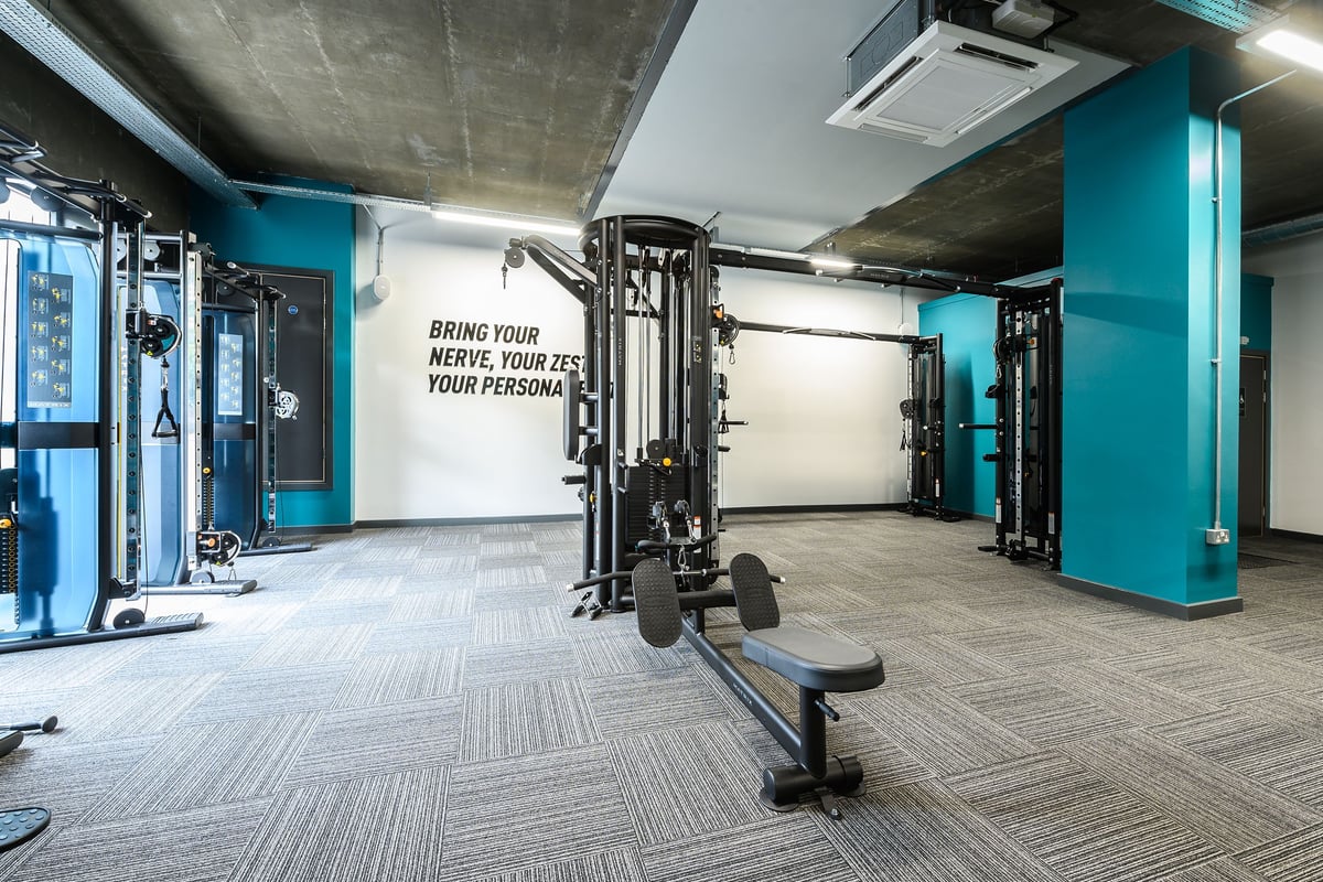 PureGym London Camberwell Southampton Way: Weight training area with resistance machines, benches, and teal accents on walls.