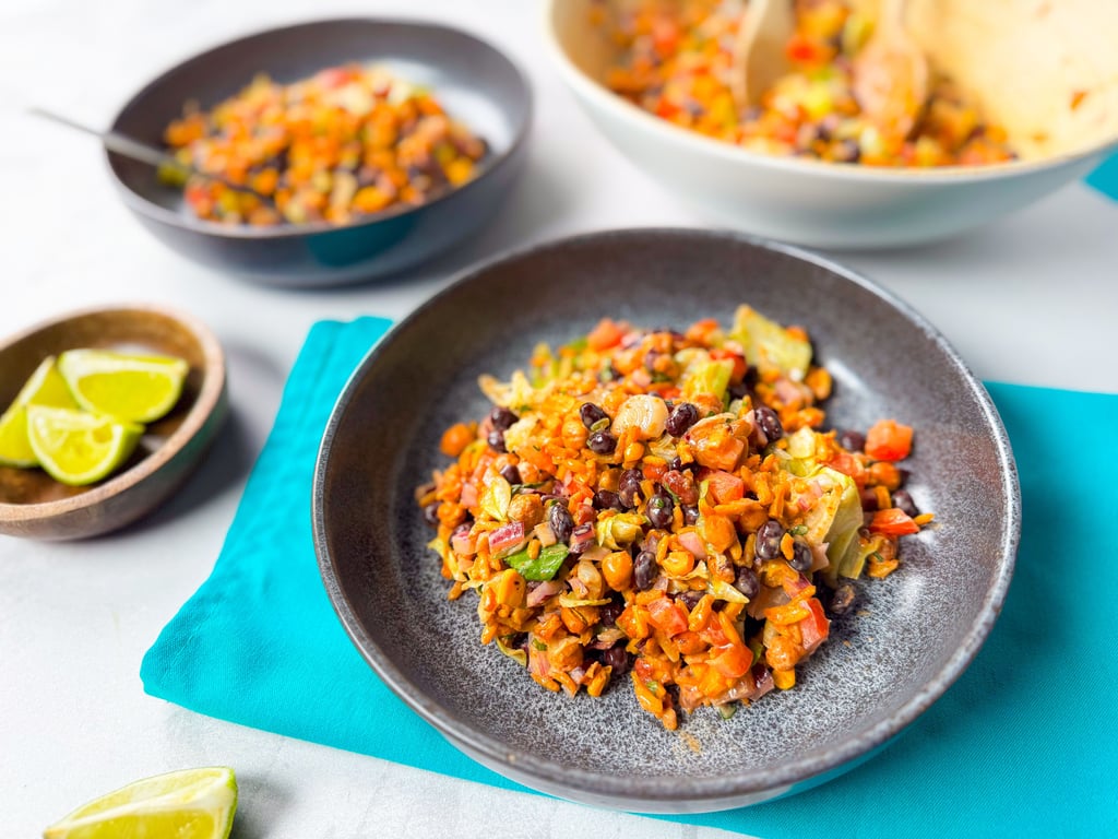 Mixed bean and vegetable salad served in grey bowls with lime wedges on the side