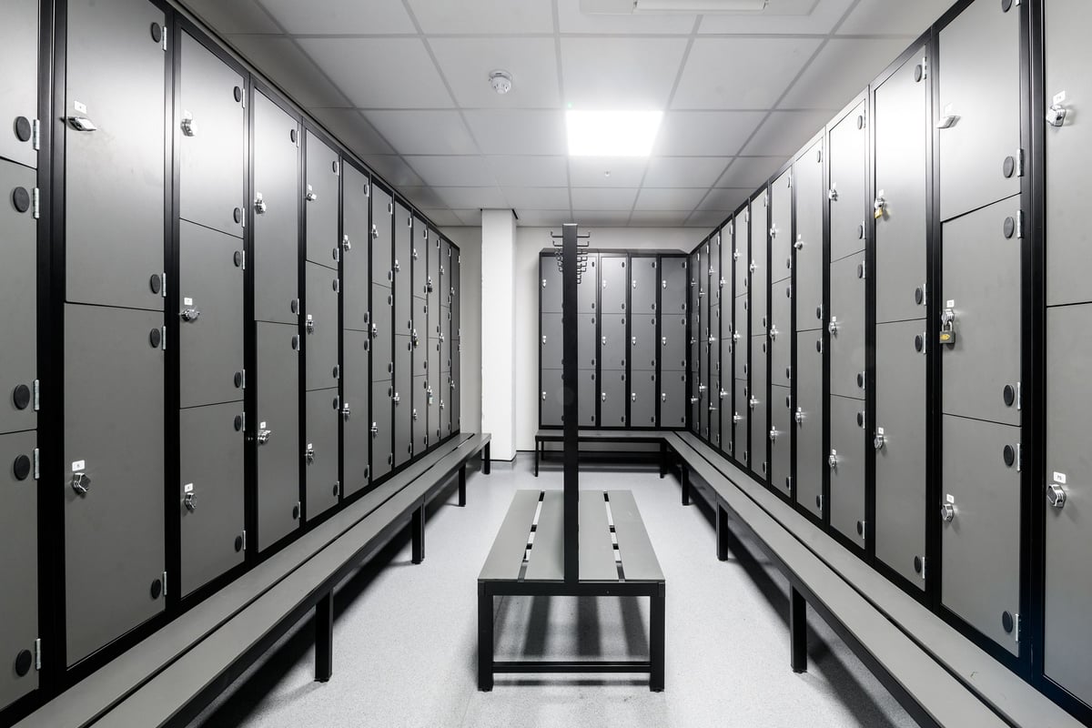 PureGym Basildon: Rows of metal lockers with benches in the middle aisle.