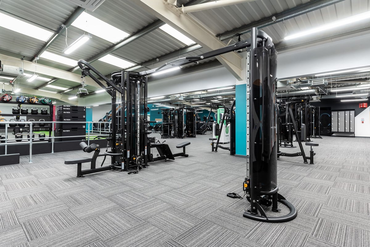 PureGym Cardiff Western Avenue: Resistance machines, benches, free weights, and rubberized flooring in a gym training area.