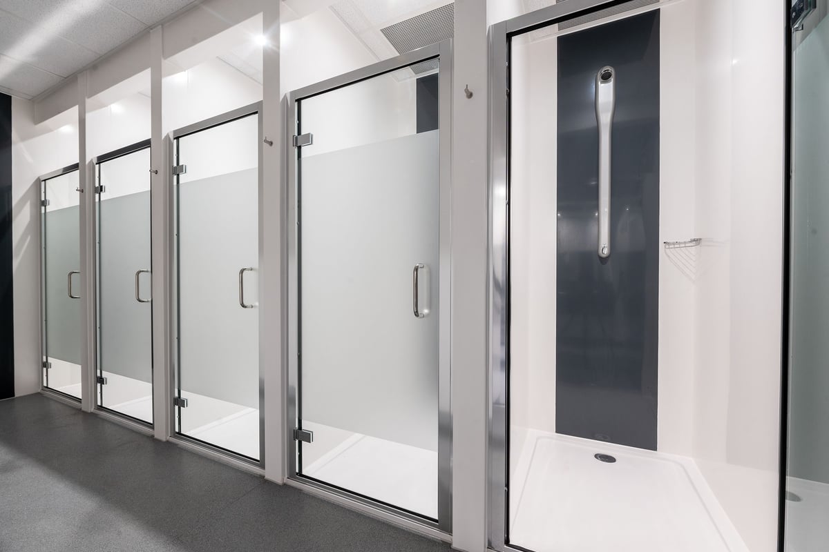 PureGym Yeovil Houndstone Retail Park: Rows of stainless steel lockers and changing room cubicles with full-length doors.