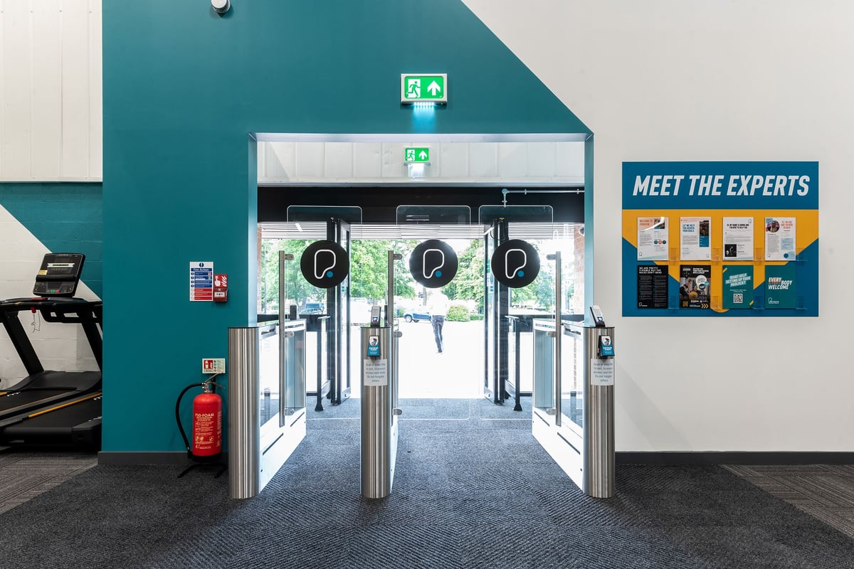 PureGym Northallerton: Turnstiles, entry vestibule, and wall signage indicating fitness experts.