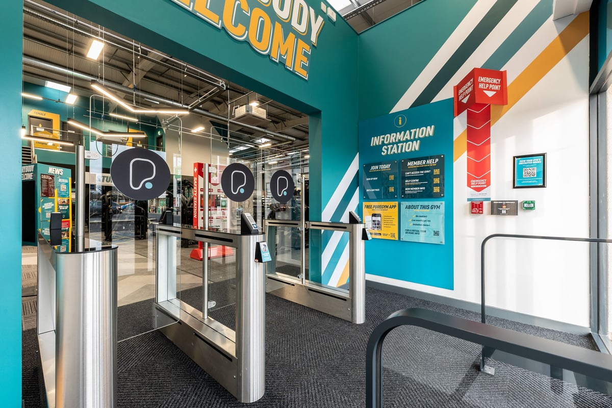 PureGym Blyth: Turnstiles, information station, and welcoming signage at a gym entrance.