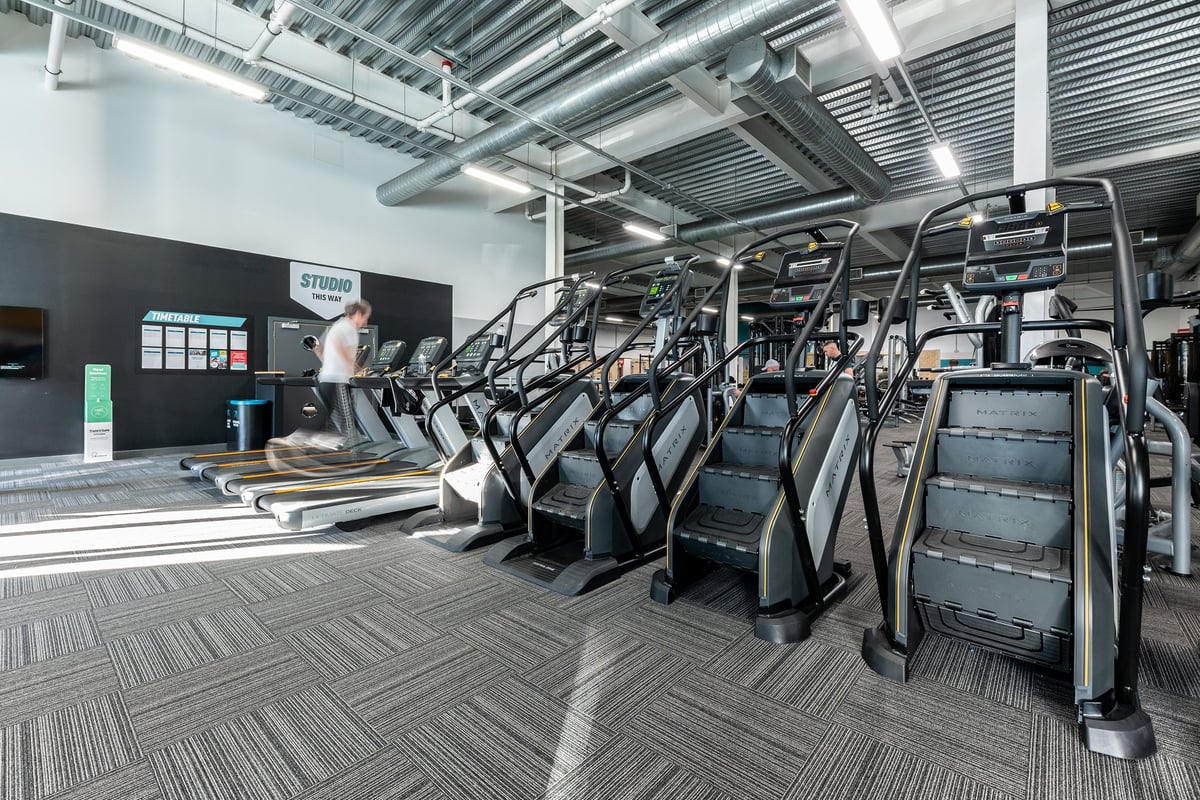 PureGym Hednesford Cannock: Rows of treadmills, ellipticals, and exercise bikes inside a fitness centre.