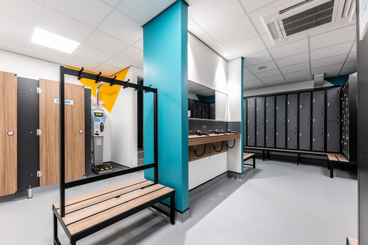 PureGym Sheffield Meadowhall Retail Park: Squat racks, bench, lockers, and wooden accents in a modern gym studio space.