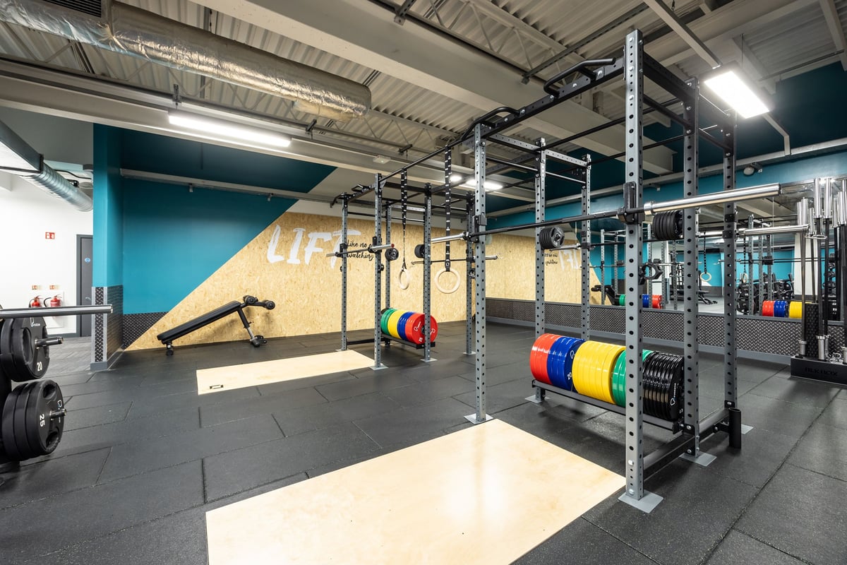 PureGym Motherwell: Rig with climbing wall, weight racks, medicine balls, rubberized flooring in functional training area.