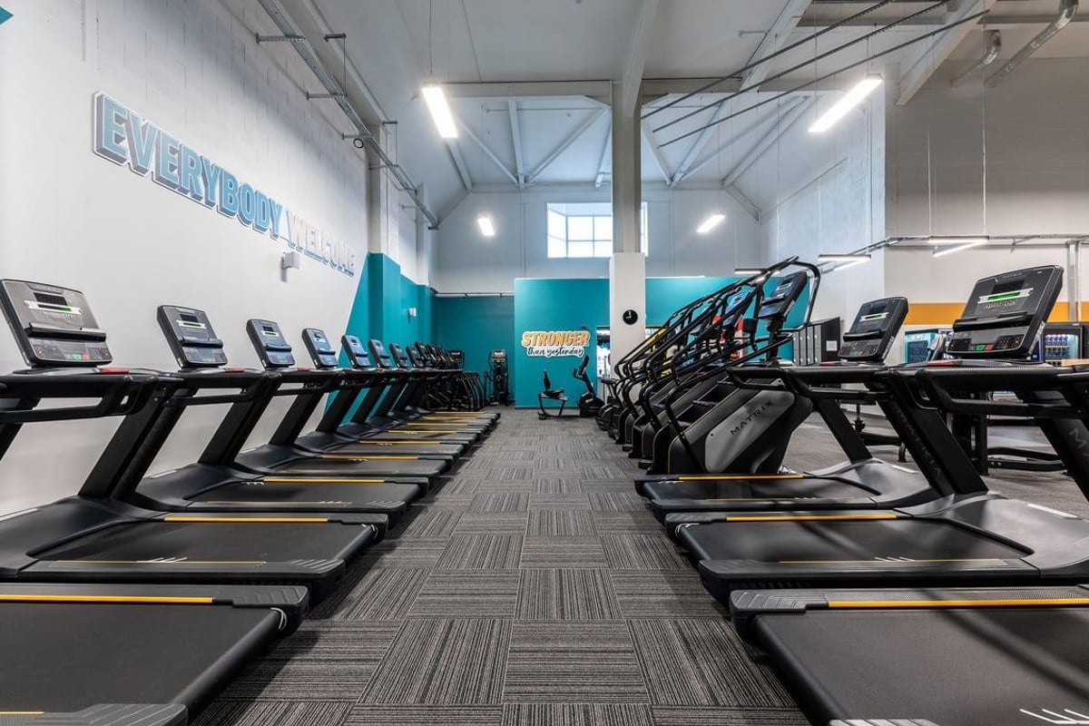 PureGym Lincoln Carlton Centre: Rows of treadmills and elliptical machines in a brightly lit gym facility.
