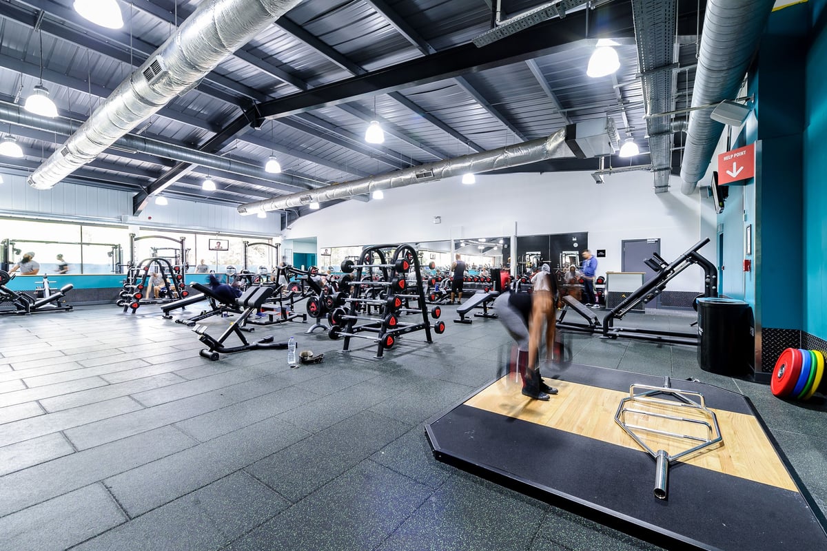 PureGym Leicester Walnut Street: Gym interior with weight machines, free weights, benches, and ductwork on ceiling.