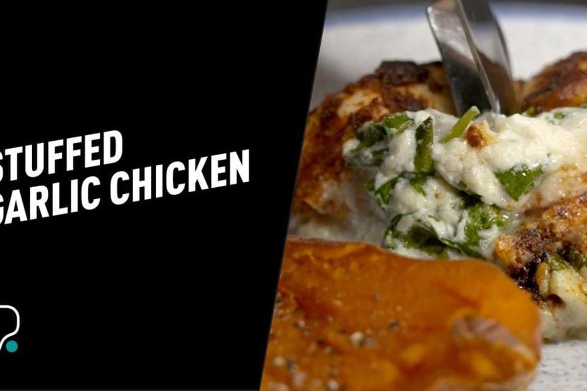 Stuffed chicken breast with melted cheese being lifted with a fork